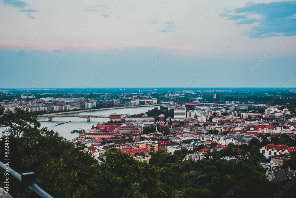 Fototapeta premium Aerial view of Budapest's vibrant city skyline in the evening, framed by the calm waters