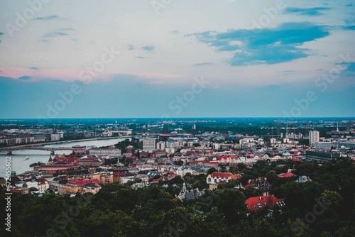 Aerial view of Budapest's vibrant city skyline in the evening, framed by the calm waters © Wirestock