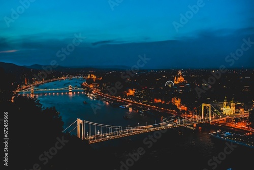 Aerial view of Budapest cityscape with a bridge spanning a river in the city during a golden sunset