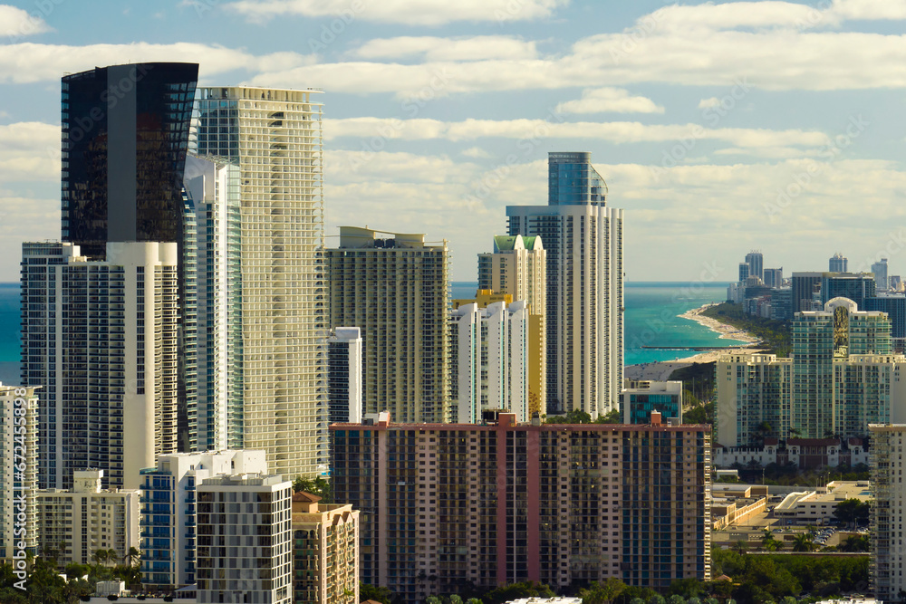 Obraz premium Sunny Isles Beach city with luxurious highrise hotels and condo buildings on Atlantic ocean shore. American tourism infrastructure in southern Florida