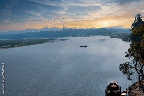 Sailor navigating a vessel on a stunning river, with birds soaring in the sky above