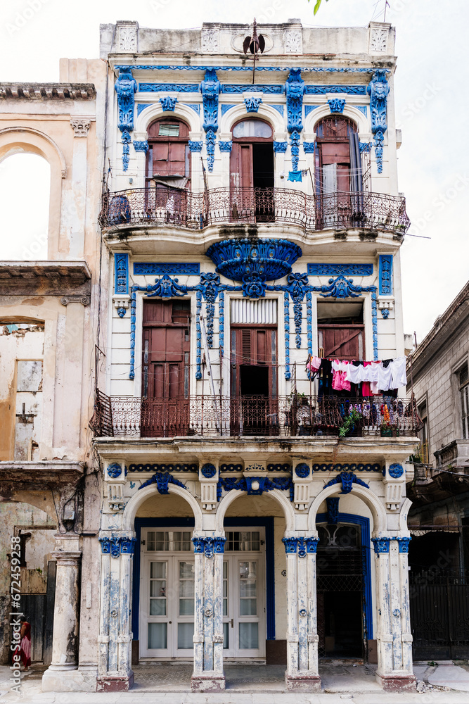 Vertical shot of a quaint, aesthetic white building with blue ornaments in Havana, Cuba