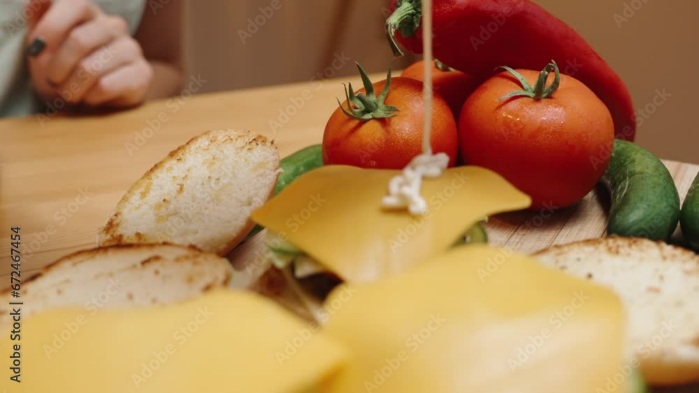 The Preparation of Homemade Burgers, a Woman Pours White Sauce over the Cheese. Slow Motion, Close-Up, in Motion. The Preparation of Homemade Burgers, a Woman Pours White Sauce over the Cheese. Slow Motion, Close-Up, in Motion.