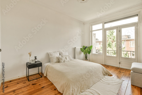a bedroom with wood floors and white walls, including a bed in the center of the room there is a small table on the © Casa imágenes