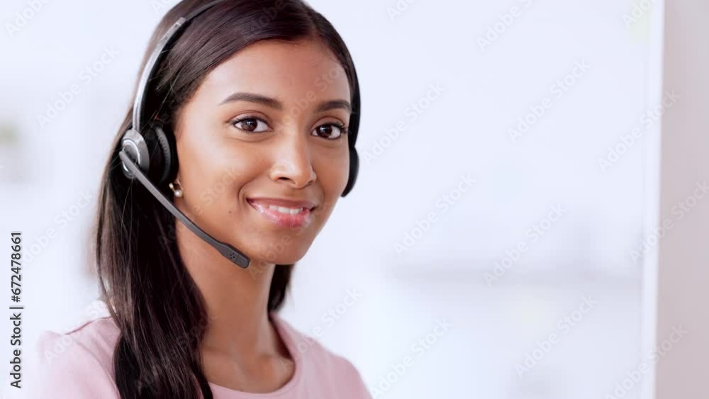 Call centre agent wearing headset and assisting with online enquiry for customer support service. Portrait of young sales representative smiling while making a sale at her helpdesk in the office Call centre agent wearing headset and assisting with online enquiry for customer support service. Portrait of young sales representative smiling while making a sale at her helpdesk in the office
