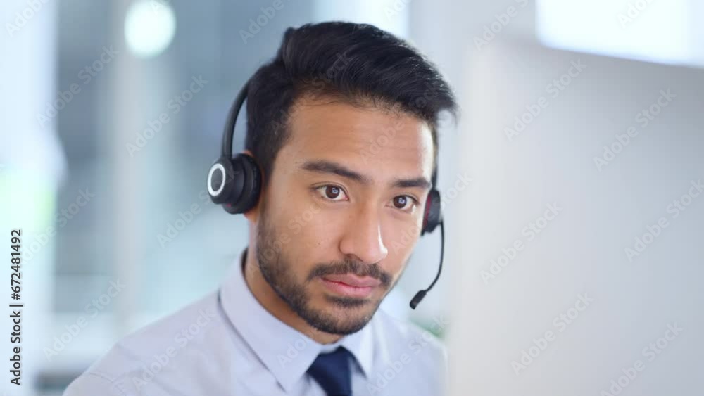 Call centre agent wearing headset giving great customer support service via email at his desk. Confident young sales representative making a sale at his helpdesk in the office.