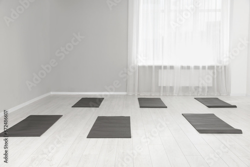 Spacious yoga studio with exercise mats. Space for text