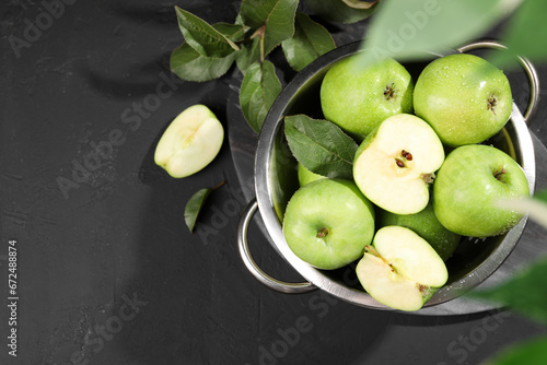 Ripe green apples with water drops and leaves on black table, flat lay. Space for text © New Africa