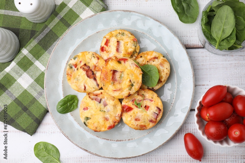 Delicious egg muffins with cheese and bacon on white wooden table, flat lay Delicious egg muffins with cheese and bacon on white wooden table, flat lay