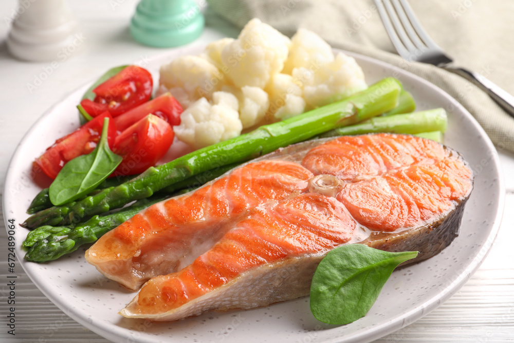 Healthy meal. Grilled salmon steak and vegetables served on white wooden table, closeup
