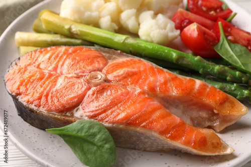 Healthy meal. Grilled salmon steak and vegetables served on white table, closeup