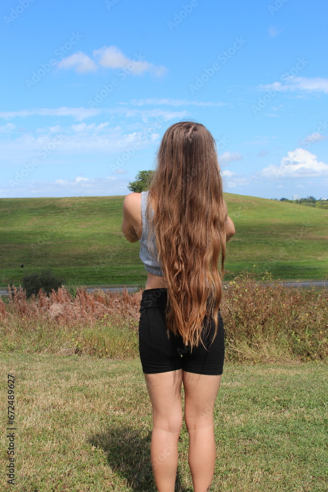 Long light brunette hair with a hill background Long light brunette hair with a hill background