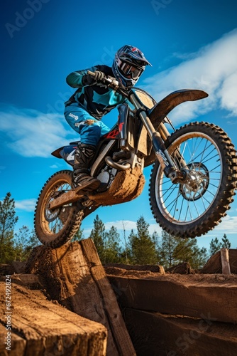 Motocross rider on a cross country bike jumping over obstacles.