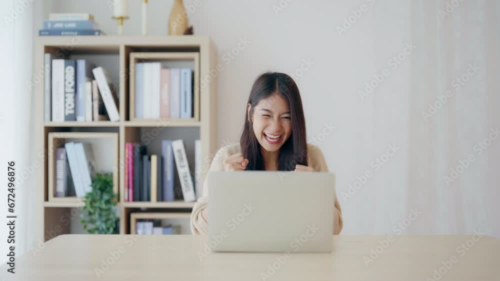 Funny euphoric young asian woman celebrating winning or getting ecommerce shopping offer on computer laptop. Excited happy girl winner looking at notebook celebrating success Funny euphoric young asian woman celebrating winning or getting ecommerce shopping offer on computer laptop. Excited happy girl winner looking at notebook celebrating success