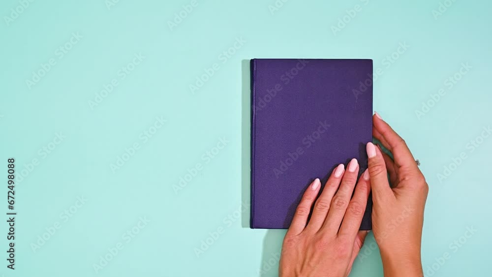 Woman Unveils Blank Page with Grace on dark blue vintage book on mint green background Woman Unveils Blank Page with Grace on dark blue vintage book on mint green background