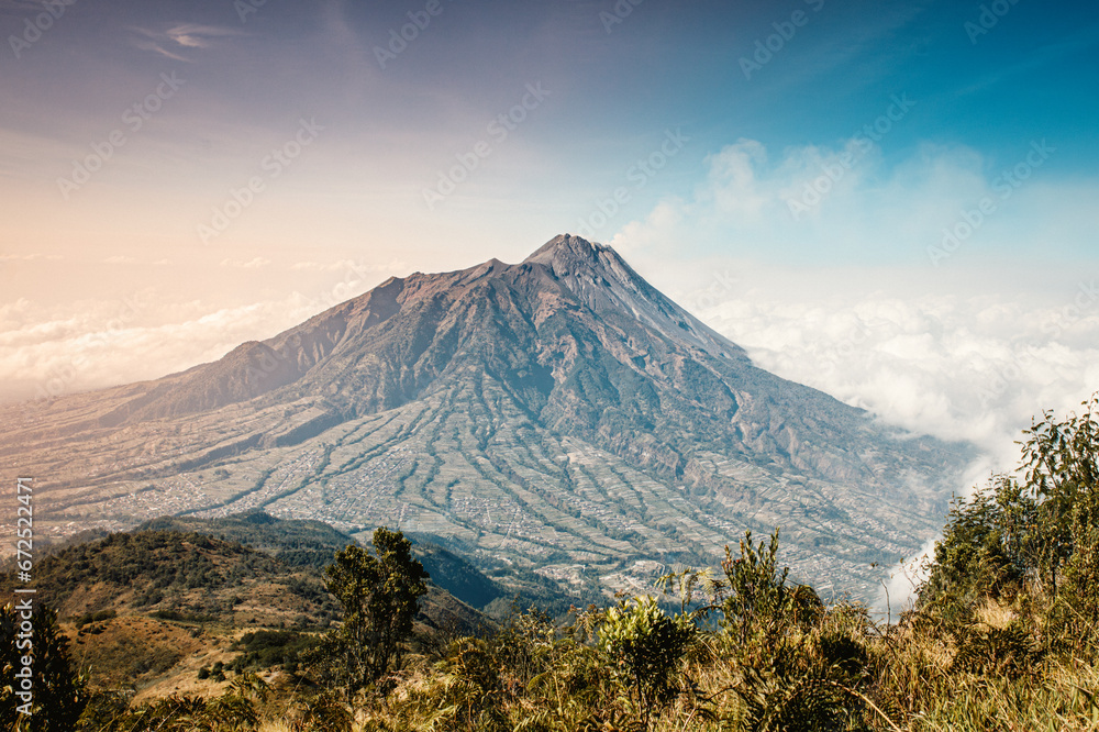Panoramic view of mount Merapi from its opposite mount Merbabu in central part of Java island in Indonesia, Southeast Asia Panoramic view of mount Merapi from its opposite mount Merbabu in central part of Java island in Indonesia, Southeast Asia