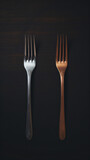 two forks are shown on a black surface