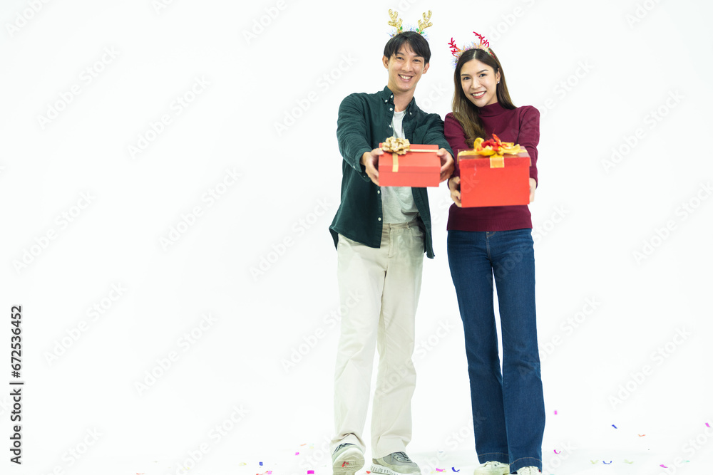 Young Asian couple two friends man woman wearing casual clothes and holding present red box with gifts together isolated on white background studio portrait. concept new year and christmas gifts. Young Asian couple two friends man woman wearing casual clothes and holding present red box with gifts together isolated on white background studio portrait. concept new year and christmas gifts.
