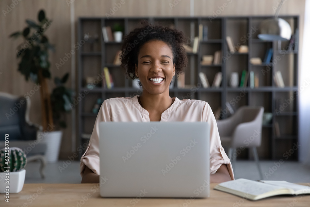 Happy African American student girl laughing at computer, watching ...
