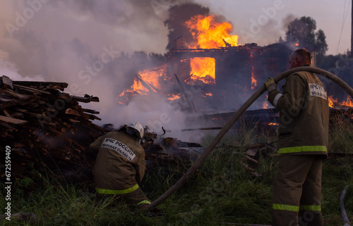 Fire service employees extinguish the fire. Firefighters at the scene of the fire. A fire in the village. Burning wooden houses in the village of Rantsevo, Tver region. photo