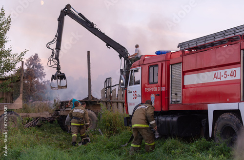 Fire service officers arrived at the scene. A fire truck at the scene of the fire. A fire in the village. Burning wooden houses in the village of Rantsevo, Tver region. photo