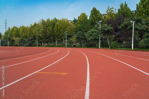 Athlete track or running track with green trees in the playground © zhikun sun