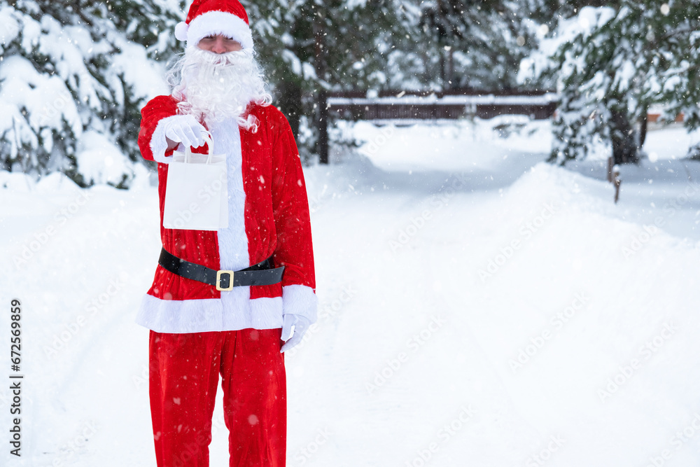 Santa Claus outdoor in winter and snow handing in hand paper bags with craft gift, food delivery. Shopping, packaging recycling, handmade, delivery for Christmas and New year Santa Claus outdoor in winter and snow handing in hand paper bags with craft gift, food delivery. Shopping, packaging recycling, handmade, delivery for Christmas and New year