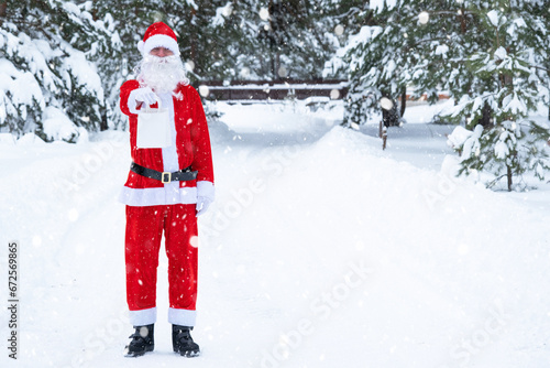 Santa Claus outdoor in winter and snow handing in hand paper bags with craft gift, food delivery. Shopping, packaging recycling, handmade, delivery for Christmas and New year © Ольга Симонова