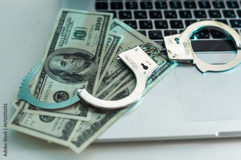 Pair of handcuffs closeup on dollar banknotes background. Corruption problem in the world Pair of handcuffs closeup on dollar banknotes background. Corruption problem in the world