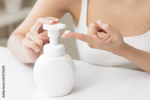 Healthy skin care,beauty asian young woman with lotion after shower bath at home, squeeze out moisturizer from bottle, putting on her hand. Skin body cream moisturizing lotion, routine in the morning.