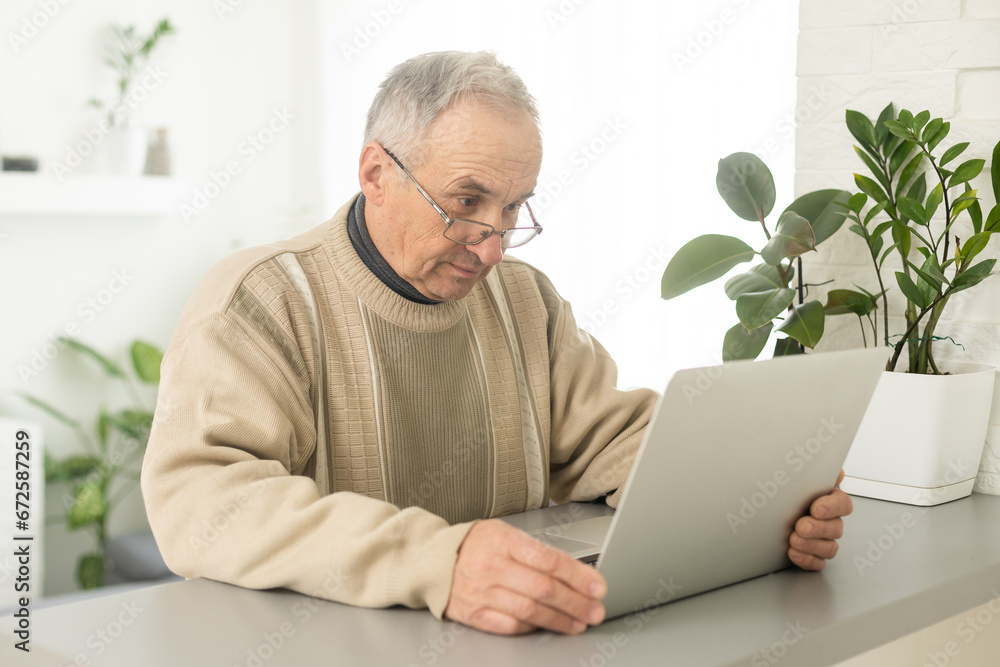 Senior man with eyeglasses connected with laptop at home. Senior man with eyeglasses connected with laptop at home.