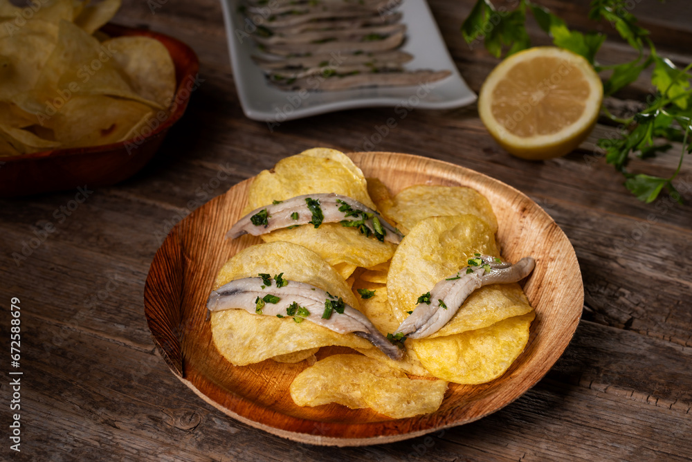 Bowl with chips and anchovies in vinegar, typical bar tapa in southern Spain, close-up. Bowl with chips and anchovies in vinegar, typical bar tapa in southern Spain, close-up.