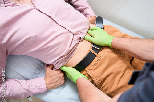 Tableau sur toile Experienced therapist palpates the patients abdomen