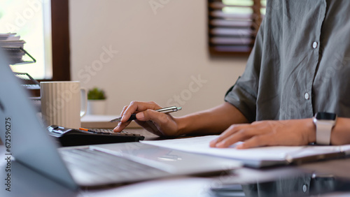 Casual business women using calculator to checking financial paper and analysis marketing strategy