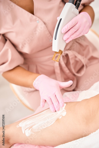 Cosmetologist lubricates the patients hands with a protective cream