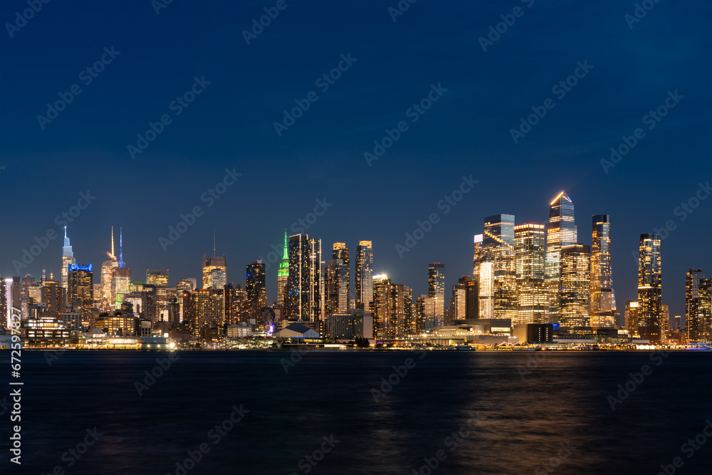 New York west side skyline at night with lights, panoramic business skyscrapers