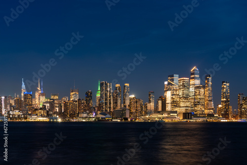 New York west side skyline at night with lights, panoramic business skyscrapers