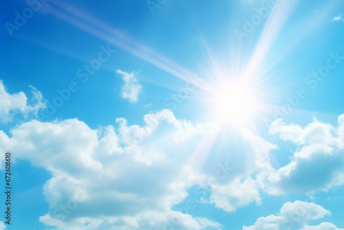 Bright sunshine with sun flares and clouds on clear blue sky background, hot summer concept