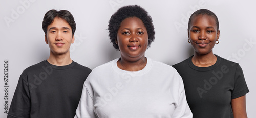 Photo collage of three people with calm confident expressions look directly at camera dressed in casual clothing pose against white background in studio. Dark skinned African plump woman with friends