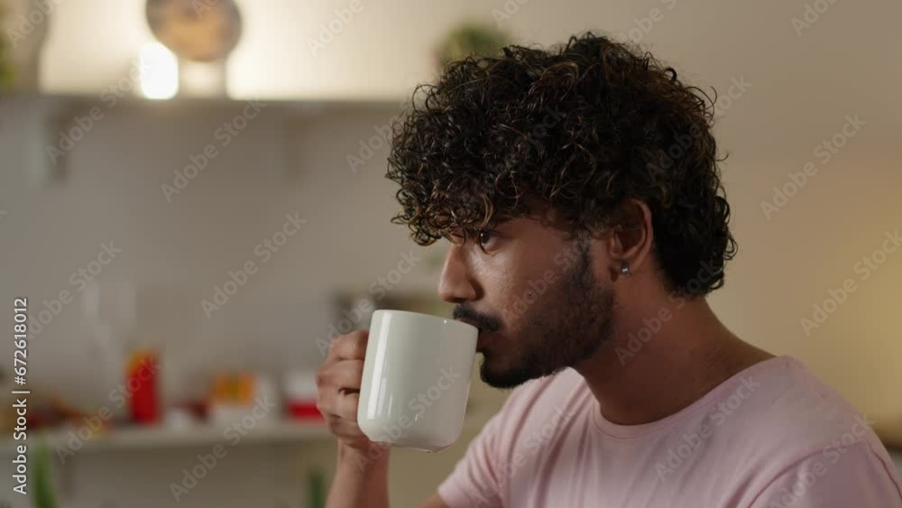 Concept of breakfast. Young guy eating tasty toast and drinking a cup coffee. Man consumes unhealthy bread sandwich with tea at home kitchen. Relaxed student has lunch Concept of breakfast. Young guy eating tasty toast and drinking a cup coffee. Man consumes unhealthy bread sandwich with tea at home kitchen. Relaxed student has lunch