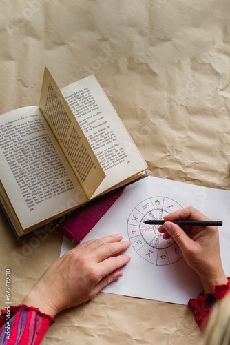 Hands of a woman writing an astrological chart