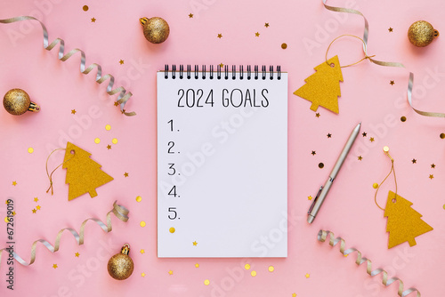 New year resolutions 2024 on desk. 2024 goals list with notebook on festive pink background. Resolutions, plan, goals, actions, checklist, idea concept
