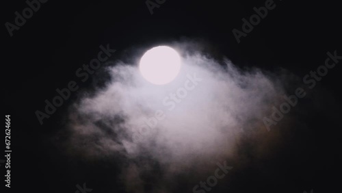 Waning gibbous moon at 92 percent illuminated with clouds drifting past in the dark night sky over Woy Woy, NSW, Australia photo