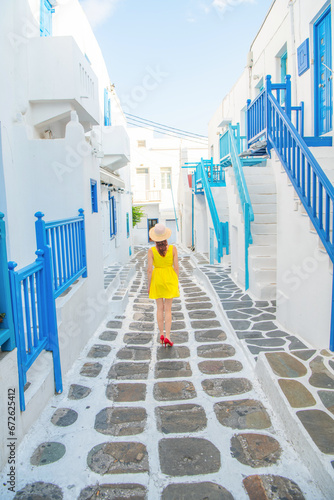 Woman in yellow dress at the Streets of old town Mykonos during a vacation in Greece, Little Venice Mykonos Greece © Kyrenian