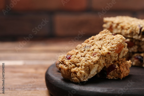 Tasty granola bars on wooden table  closeup. Space for text