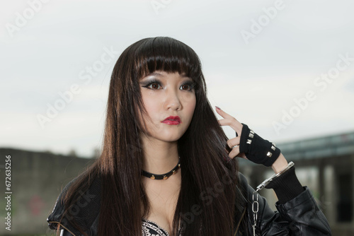 Asian woman in emo goth clothes at an abandoned building