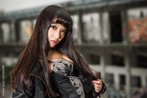 Asian woman in emo goth clothes at an abandoned building