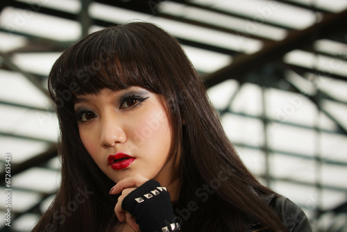 Asian woman in emo goth clothes at an abandoned building