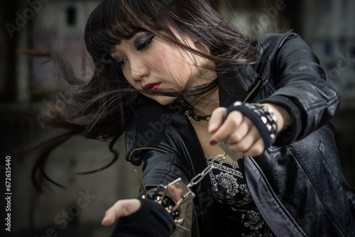 Asian woman in emo goth clothes at an abandoned building