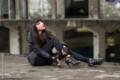 Asian woman in emo goth clothes at an abandoned building photo